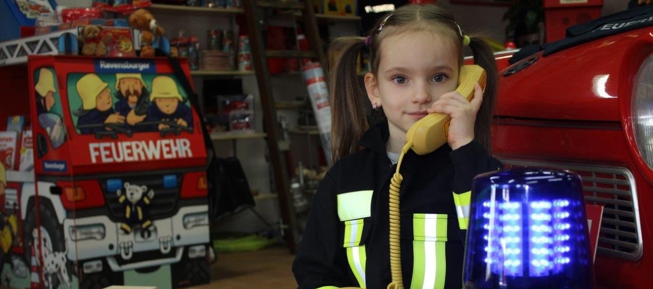 Kind bei der Brandschutzerziehung lernt Notruf